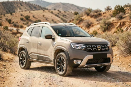 Concept de SUV Dacia à prix cassé garé sur une route de gravier en milieu rural, vue 3/4 avant