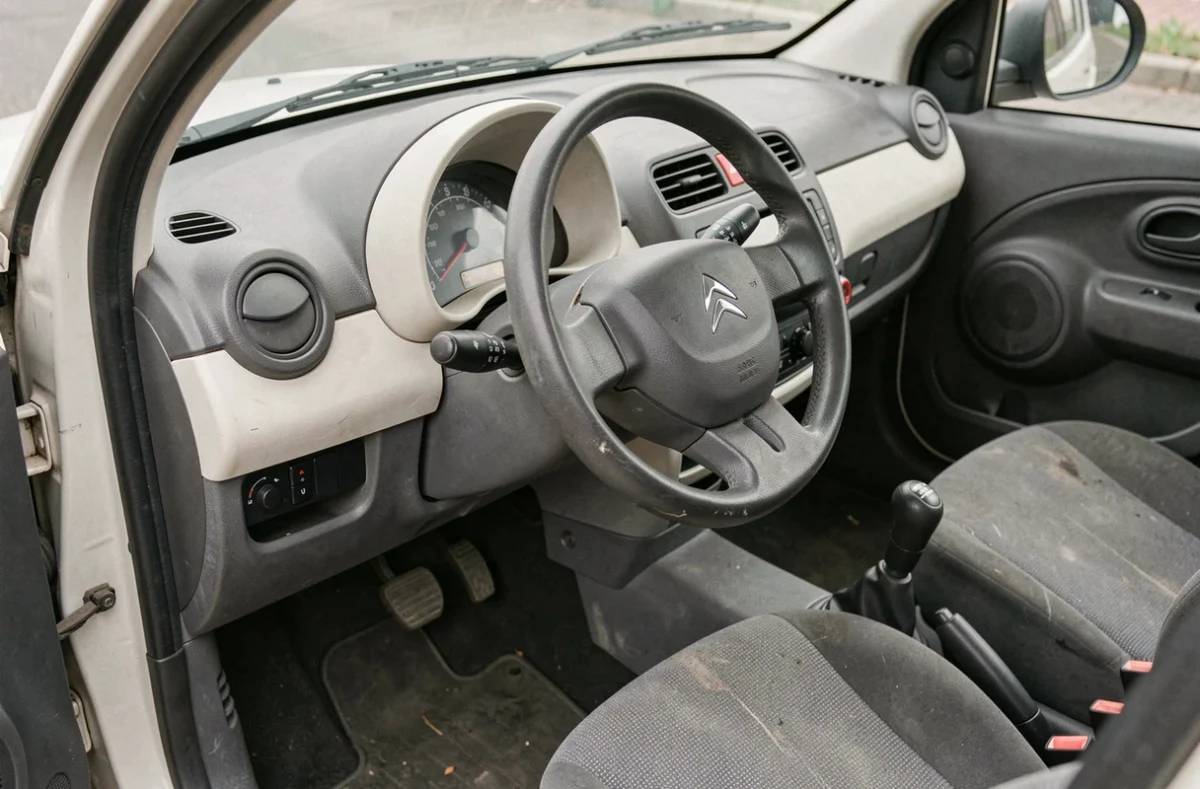 Intérieur minimaliste d'une Citroën Ami d'occasion avec tableau de bord et siège usagés