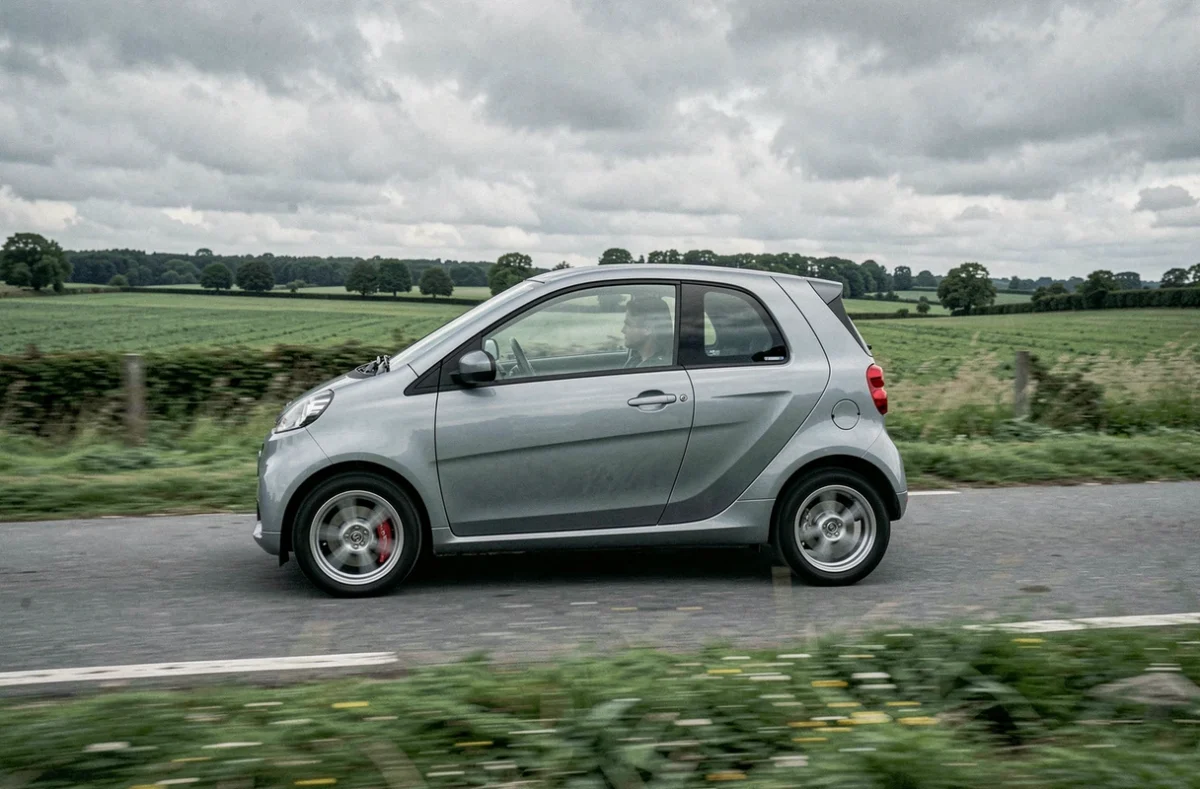 Voiture sans permis quatre places roulant sur une route de campagne française